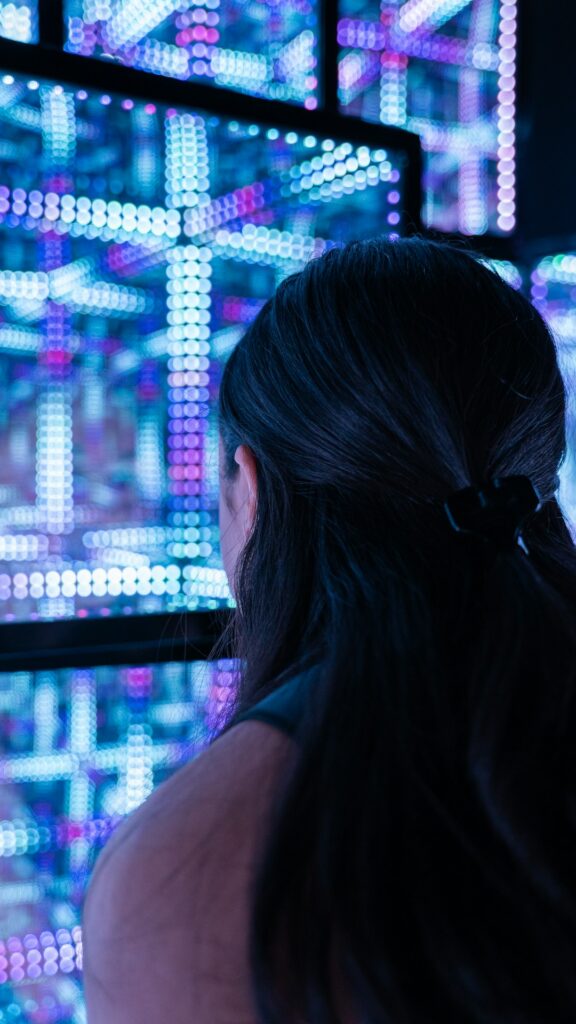 a-woman-standing-in-front-of-a-wall-of-lights-rvks9h69628